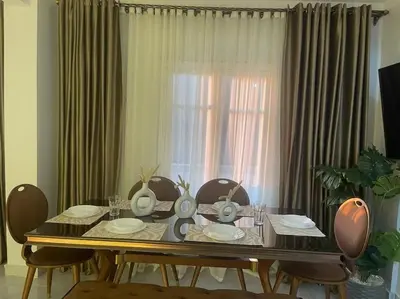 a dining room table with chairs and a window at Tony HOUSE in Aswan