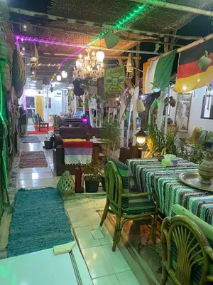 a store with tables and chairs and rugs at peace garden hostel & camp in Luxor
