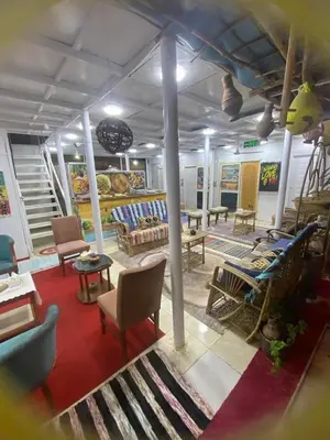 a room with couches and chairs and a table at peace garden hostel & camp in Luxor