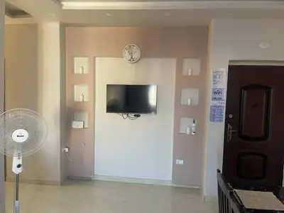 a room with a tv on a wall with a fan at Marvel lotus in Hurghada