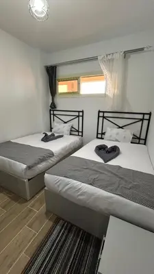 two twin beds in a room with at Bay View Sahl hasheesh Apartment Hurghada in Hurghada