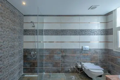 a bathroom with a toilet and a glass shower at Royal Villa on the beach in Hurghada