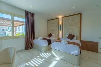 a hotel room with two beds and a couch at Royal Villa on the beach in Hurghada