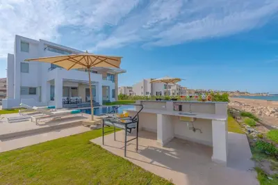 a house with a patio with a table and an umbrella at Royal Villa on the beach in Hurghada