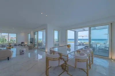 a dining room with a table and chairs and the ocean at Royal Villa on the beach in Hurghada