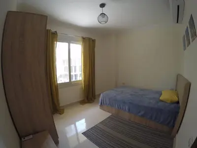 a small bedroom with a bed and a window at Andalusia Resort - 2 Bedroom Apartment in Hurghada