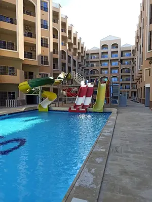 a pool with a playground in front of a apartment building at Juliana Beach Resort Hurghada in Hurghada