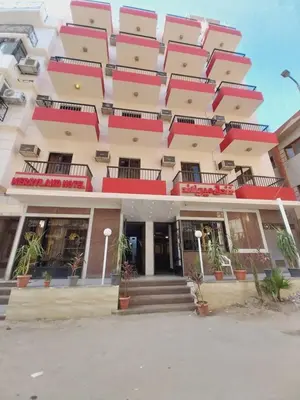 a large building with red balconies on it at Merry Land Hotel & Roof Top Nile Restaurant Luxor in Luxor