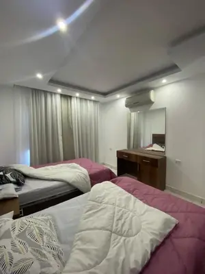 a bedroom with two beds and a vanity and a mirror at Fanadir bay in Hurghada