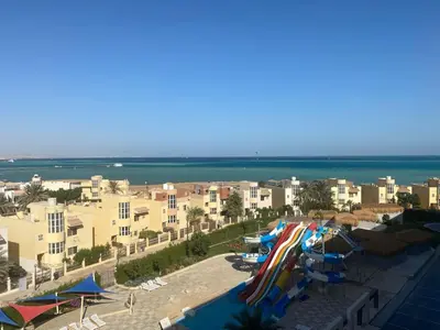 a beach with a bunch of umbrellas and the ocean at Fanadir bay in Hurghada