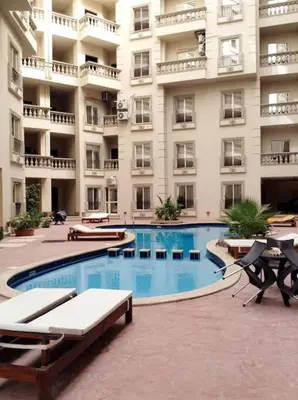 a large apartment building with a large swimming pool at Studio Cleopatra Resort in Hurghada