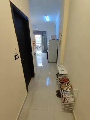 a hallway with a door and a cart of shoes at Studio Cleopatra Resort in Hurghada