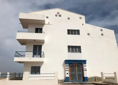 a white building with two balconies on top of it at Das Haus am Meer in Safaga