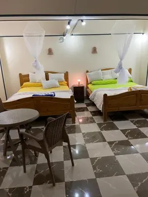 a bedroom with two beds and a table and chair at Das Haus am Meer in Safaga