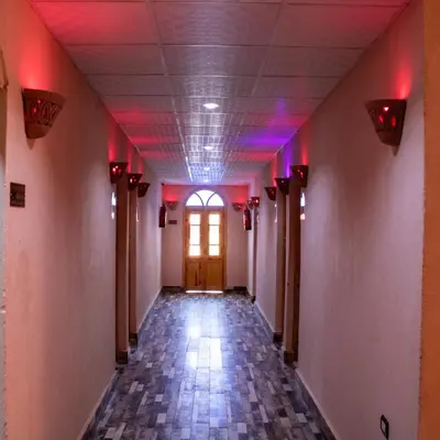 an empty hallway with red lights and a door at ACHERTOD Nubian House in Naj‘ al Maḩaţţah