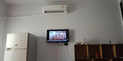 a tv on a wall in a kitchen with a refrigerator at Tibaview in Hurghada