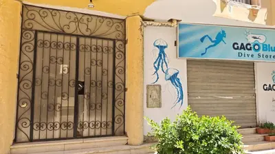 a door to a dive store with a sign on a building at Hurghada City Apartment1 in Hurghada