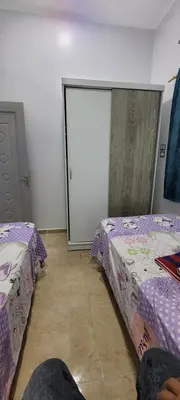a bedroom with two beds and a sliding glass door at Ahmed House 1 in Safaga
