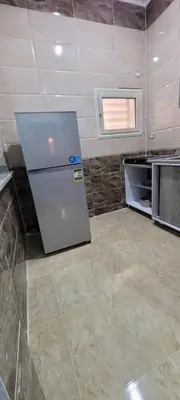 a kitchen with a refrigerator in the middle of a room at Ahmed House 1 in Safaga
