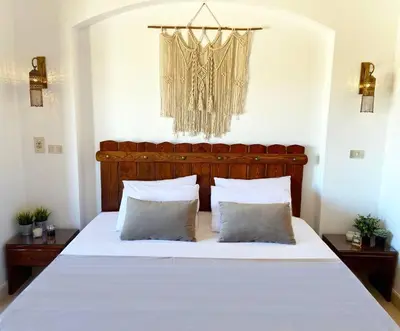 a bedroom with a large white bed with two pillows at Artsy 1 BR Apt/ Free Pool & Lagoon Access @ElGouna in Hurghada