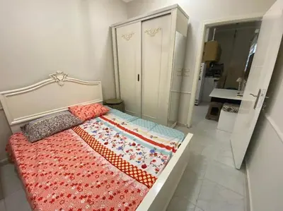 a bedroom with a bed with a red blanket on it at Уютная квартира в светлых тонах рядом с легендарной улицей Шератон в центре in Hurghada