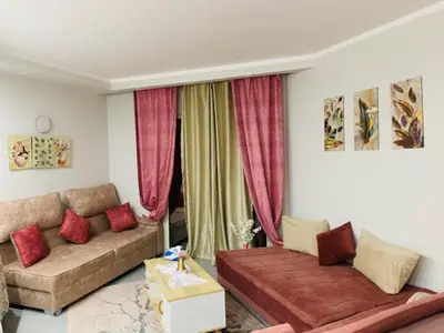 a living room with two couches and red curtains at Scandic beach resort in Hurghada