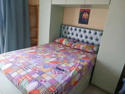 a small bedroom with a bed with a flower quilt at Harmony Sunny Chalet With Wi-Fi in Hurghada