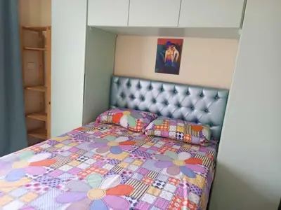 a small bedroom with a bed with a flower quilt at Harmony Sunny Chalet With Wi-Fi in Hurghada
