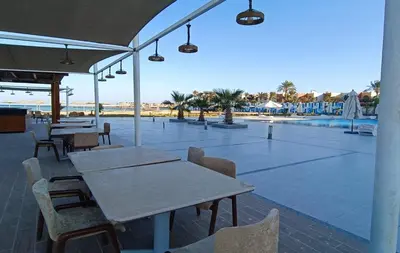 a patio with tables and chairs next to a pool at Perfect For couples Sunny & SeaView with Wi-Fi in Hurghada