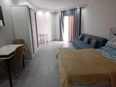 a bedroom with a bed and a table and a couch at Perfect For couples Sunny & SeaView with Wi-Fi in Hurghada