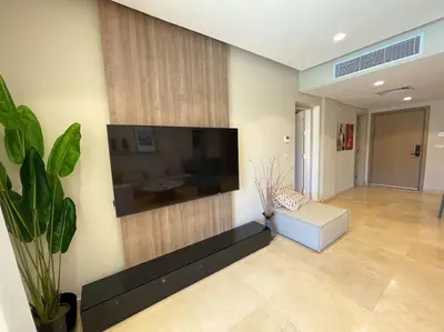 a living room with a large flat screen tv on the wall at Stunning 2 BR/ Free Beach & Pool Access @ Mangroovy, El Gouna in Hurghada