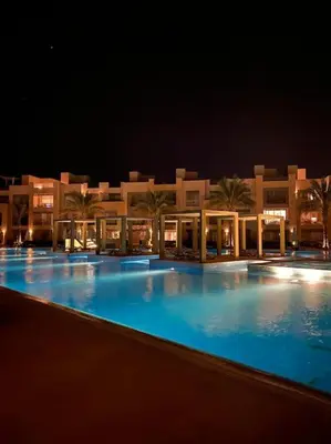 a large swimming pool in front of a building at night at Stunning 2 BR/ Free Beach & Pool Access @ Mangroovy, El Gouna in Hurghada