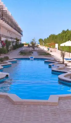 a swimming pool with blue water in front of a building at Fox House Beach Resort & Spa El Gouna in Hurghada