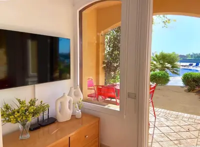 a living room with a television and a table with vases at Magical 2BR Ground/Free Pool & Lagoon Access @ElGouna in Hurghada