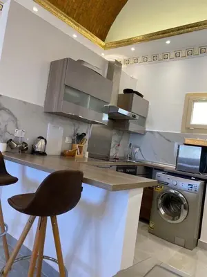 a kitchen with a counter and a washing machine at Makadi heights luxury apartment in Hurghada