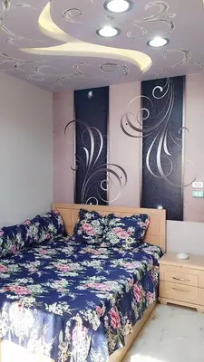 a bedroom with a bed with a blue comforter at Evi's Infinity Sea View Apartment in Hurghada