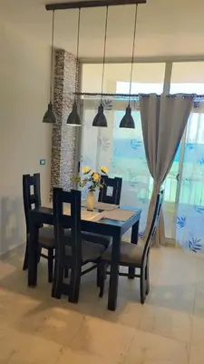 a dining room with a table and chairs and lights at Evi's Infinity Sea View Apartment in Hurghada