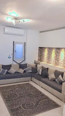 a living room with a couch and a mirror at Evi's Infinity Sea View Apartment in Hurghada