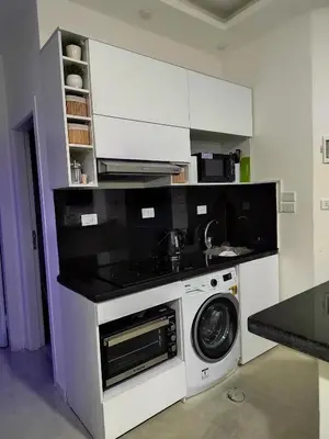 a kitchen with a washing machine and a microwave at Velký apartmán Princess Resort Hurghada in Hurghada