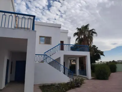 a white house with a blue stair railing at Mirage bay in Hurghada