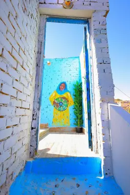 a mural of a man on a wall in a doorway at Nubian Popeye - Roof top - Nile View in Aswan