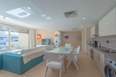 a kitchen with a bed and a table in a room at Beach-Inspired 1BR in Mangroovy, El Gouna. Sea & Pool in Hurghada