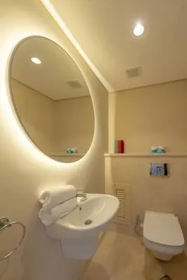 a bathroom with a sink and a mirror and a toilet at Beach-Inspired 1BR in Mangroovy, El Gouna. Sea & Pool in Hurghada