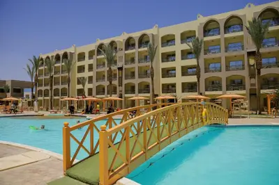 a bridge over a pool in front of a building at Go Egypt Apartments Inside Karma Beach Resort North Al Ahiaa , Hurghada in Hurghada