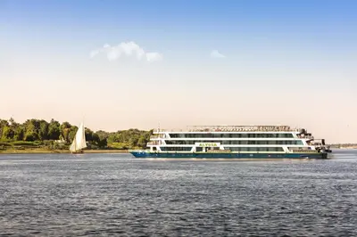 a cruise ship on the water with a sailboat at M/Y ALYSSA - 4 or 7 Nights From Luxor each Monday and 3 or 7 Nights From Aswan each Friday in Luxor