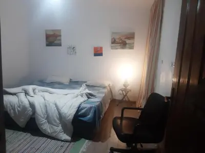 a bedroom with a bed and a chair and a lamp at Sheraton Plaza Near Marina in Hurghada