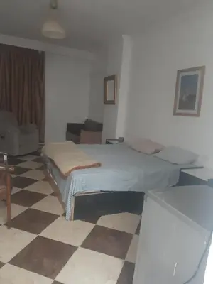 a bedroom with a bed and a checkered floor at Sheraton Plaza Near Marina in Hurghada