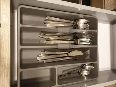 a drawer with silver utensils in a refrigerator at Mangroovy - 1BR Shiny Ground Floor in Hurghada
