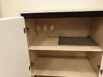 two empty wine glasses sitting on a shelf at Mangroovy - 1BR Shiny Ground Floor in Hurghada
