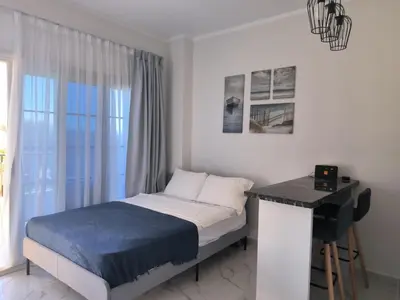 a bedroom with a bed and a desk and a window at Solo beach front studio or for couple in Hurghada